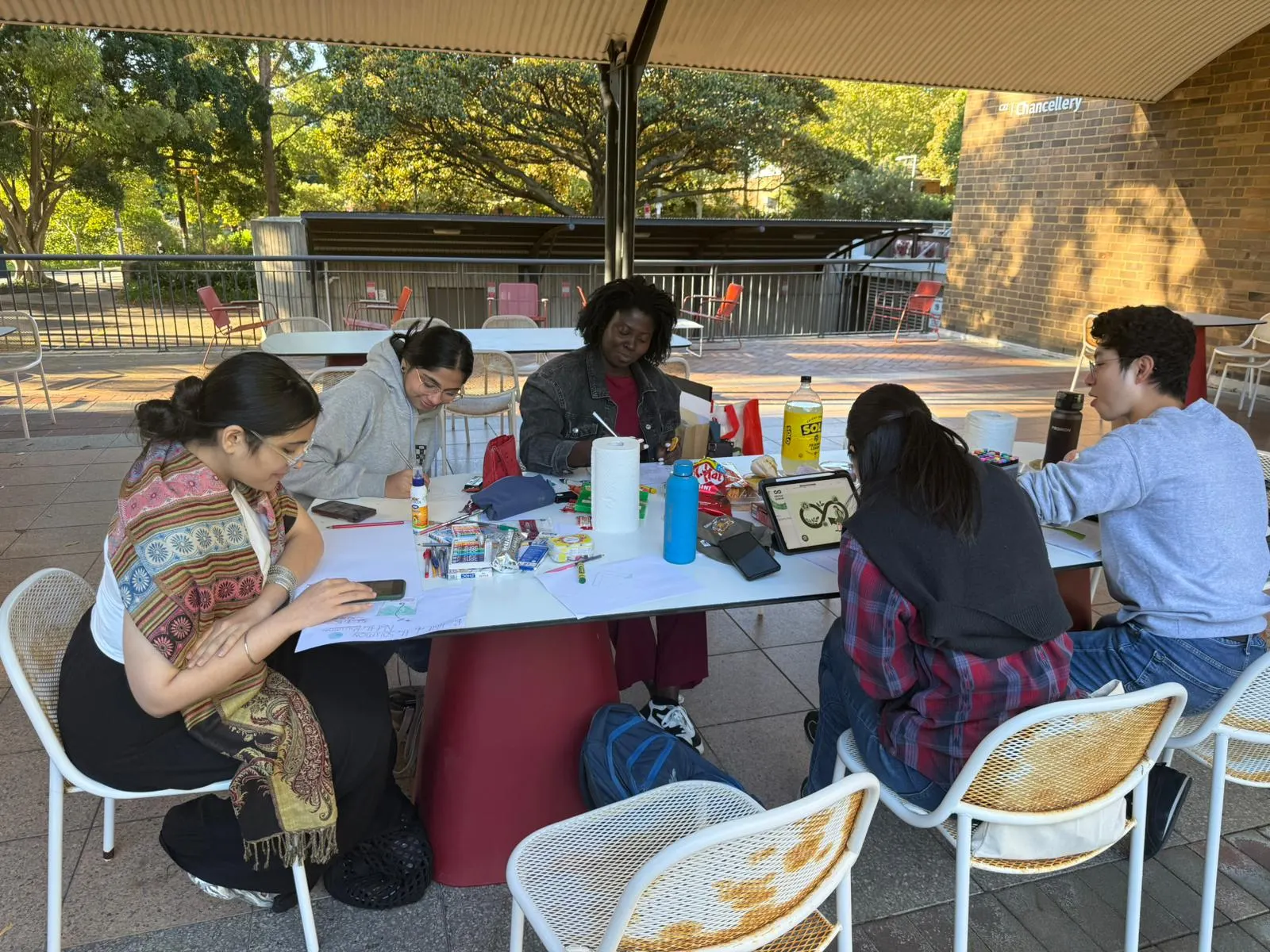 UNSW student team working together at an outdoor workshop table