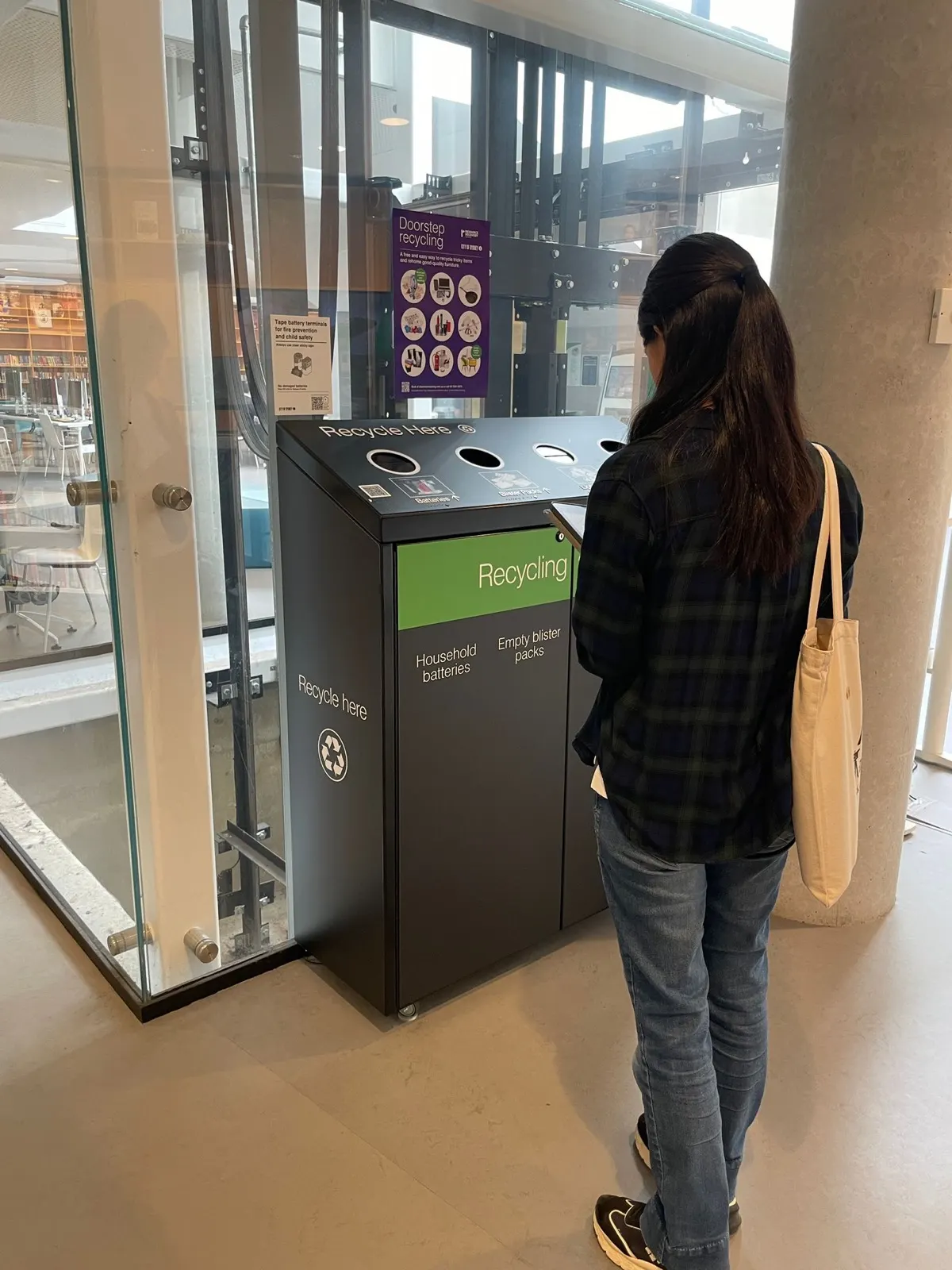 Person checking signage on a multi-stream recycling station